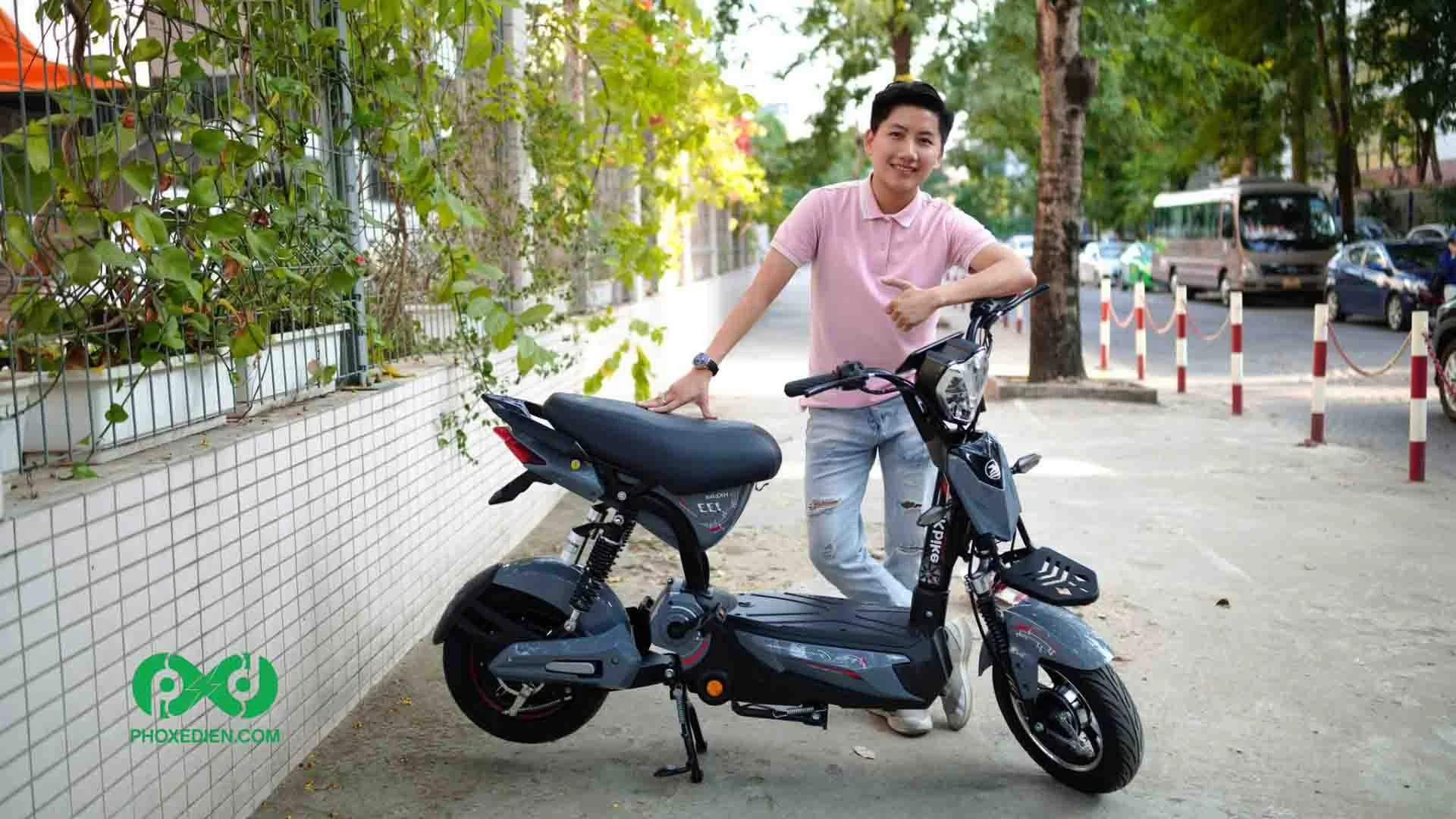 Nam thanh niên đứng cạnh mẫu xe đạp điện màu đen