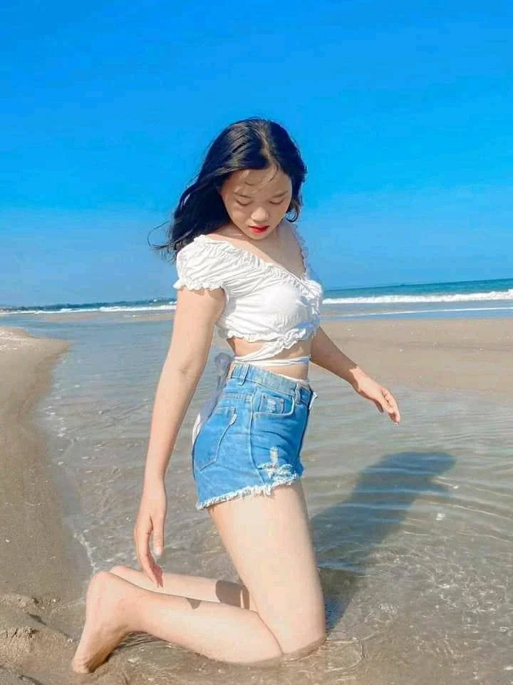 Gái mặc bikini tạo dáng bên bờ biển xanh dưới ánh nắng mùa hè