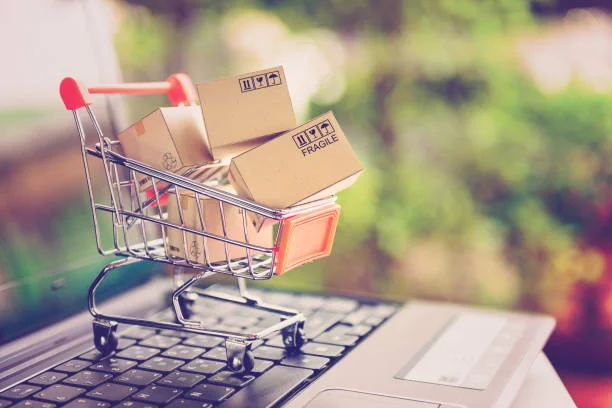 Giỏ hàng siêu thị mini đặt trên bàn phím laptop đại diện bán hàng online