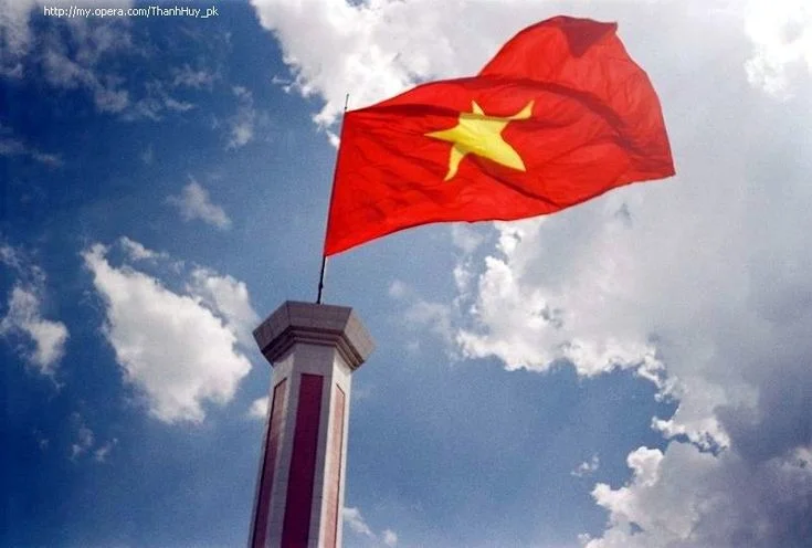 ảnh lá cờ việt nam tung bay giữa bầu trời xanh