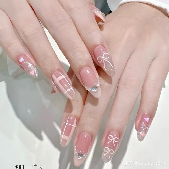 Bộ móng tay màu hồng pastel với các chi tiết nơ, kẻ caro và đính đá, thiết kế móng tay đẹp.