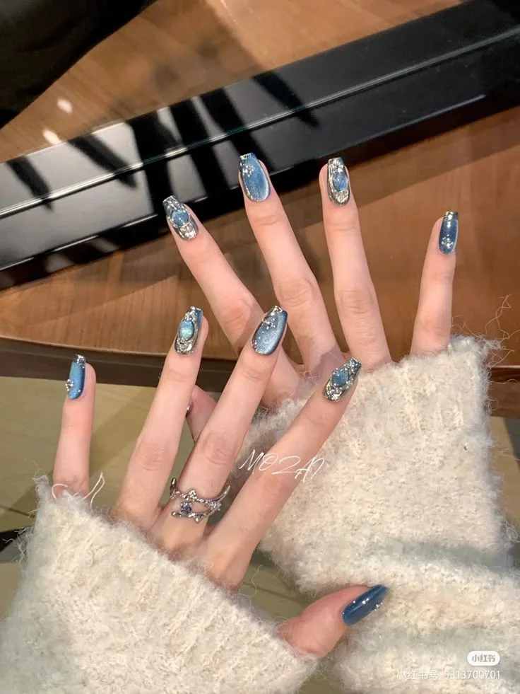 Bộ nail sơn xanh dương lấp lánh với các chi tiết đá và kim tuyến, mang đến vẻ đẹp sang trọng và thu hút.